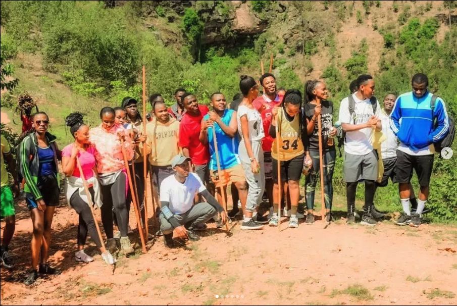 A group of trekkers with wooden walking sticks gathered before a trek
