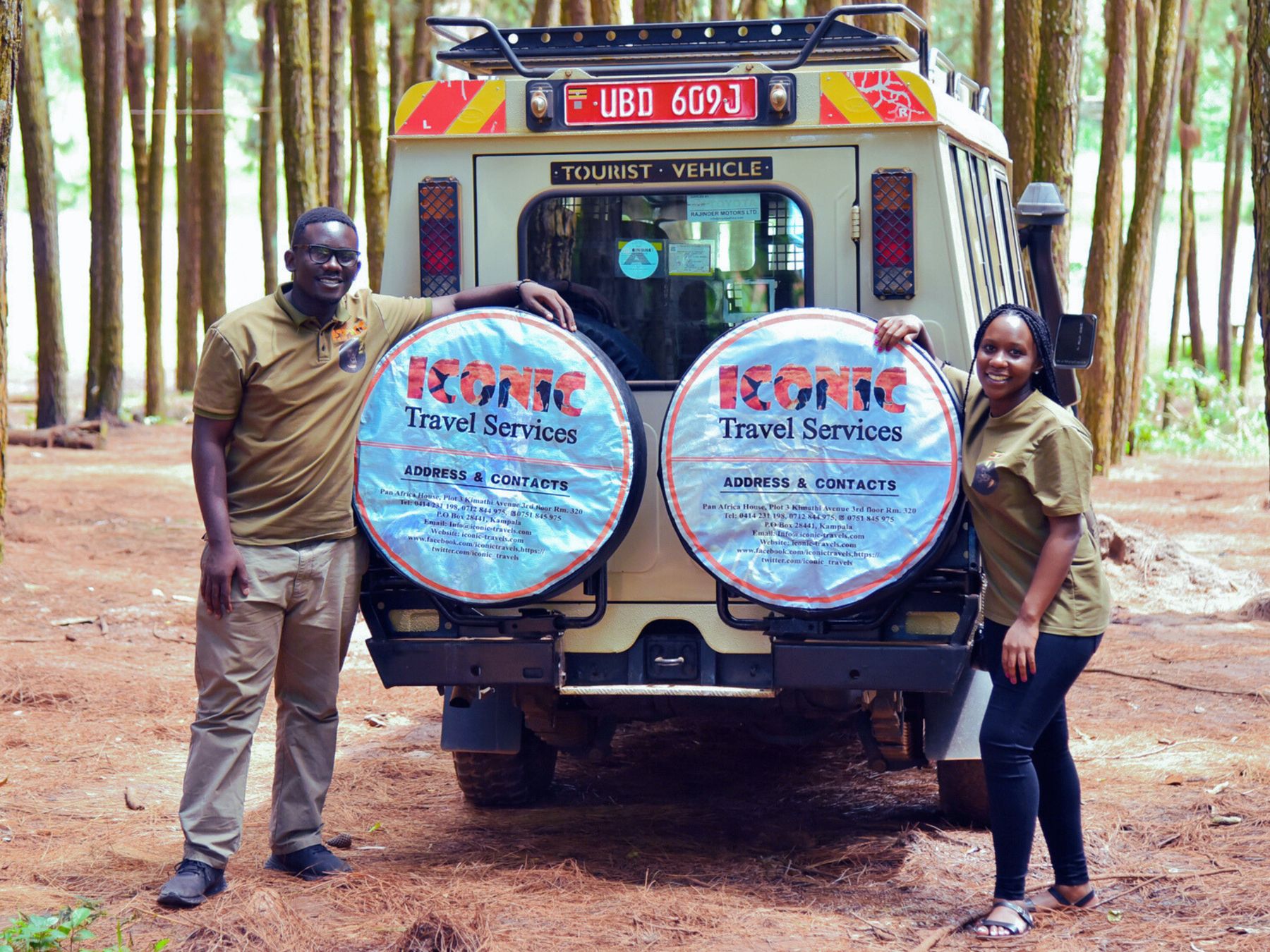 Two Iconic Travel Services staff beside a branded safari Land Cruiser